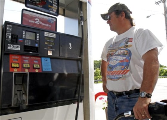 In this June 20, 2011 photo, Randy Herring fills up at a gas station in Montpelier, Vt. Drivers who feared that a summer road trip would be too expensive may hit the highway after all.
